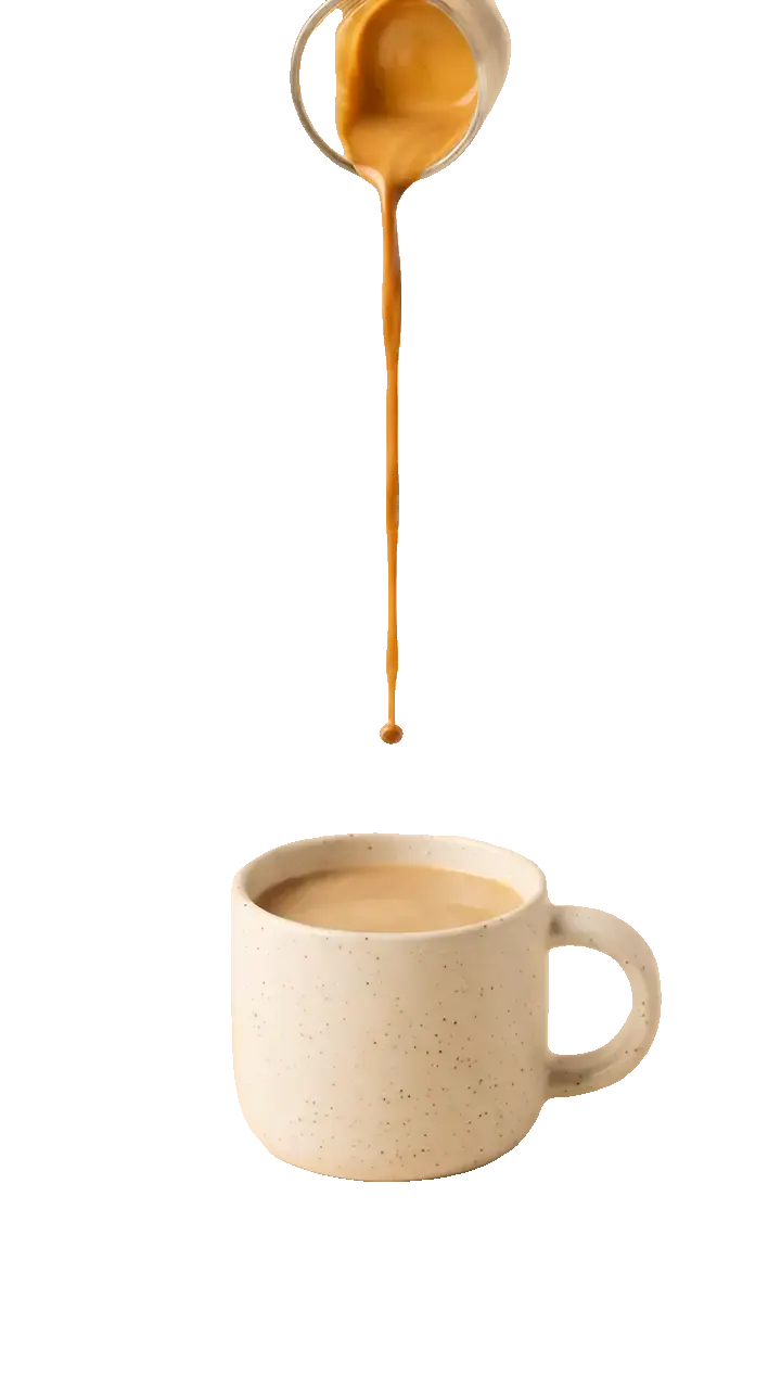 Coffee and cream spiralling into a latte in a speckled mug